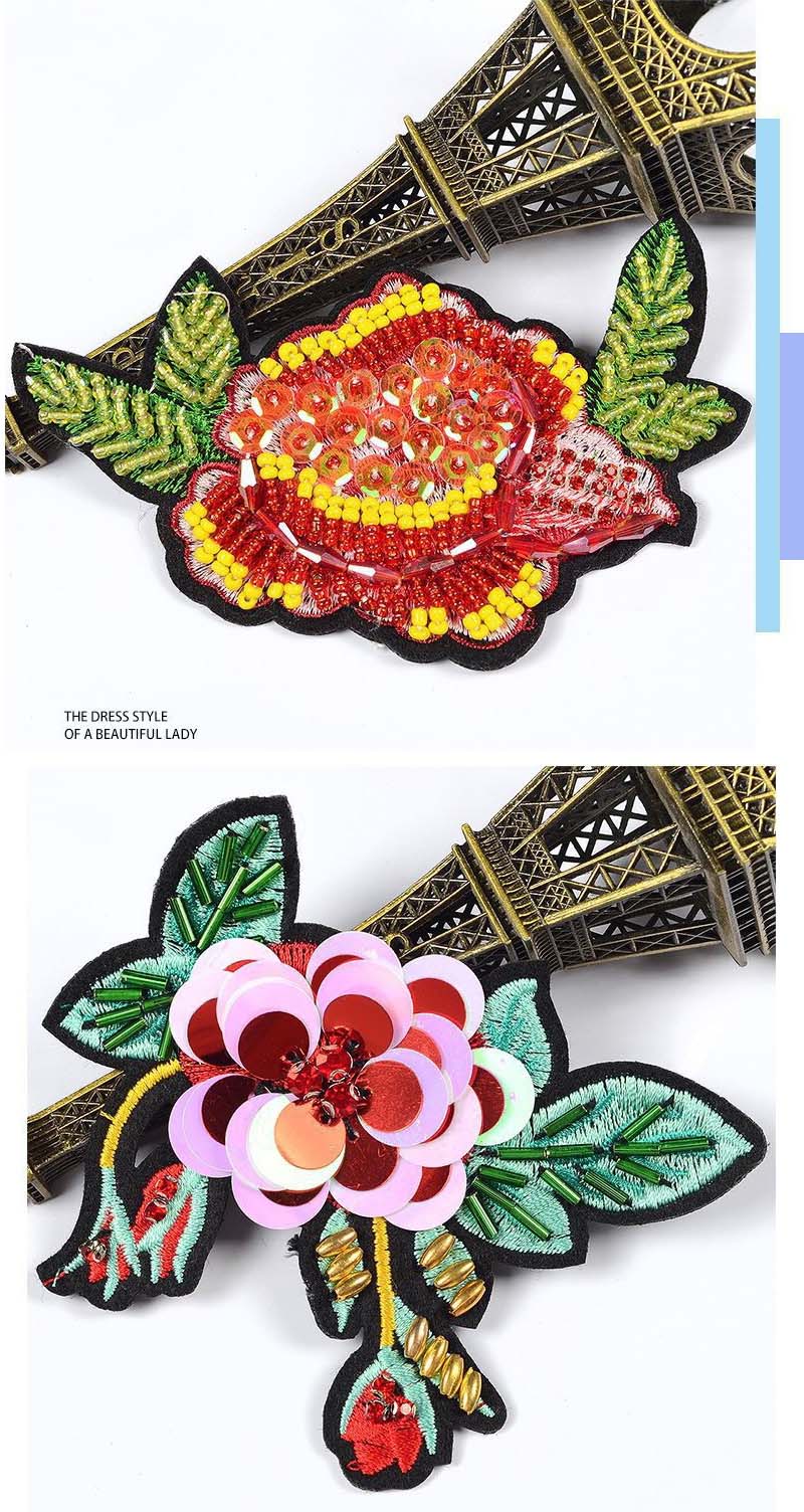 Premium hand-stitched rhinestone and sequin beaded floral embroidery patches showcased next to a decorative Eiffel Tower model.