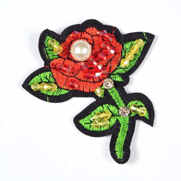 A premium handmade beaded red rose embroidered patch embellished with a large central faux pearl.